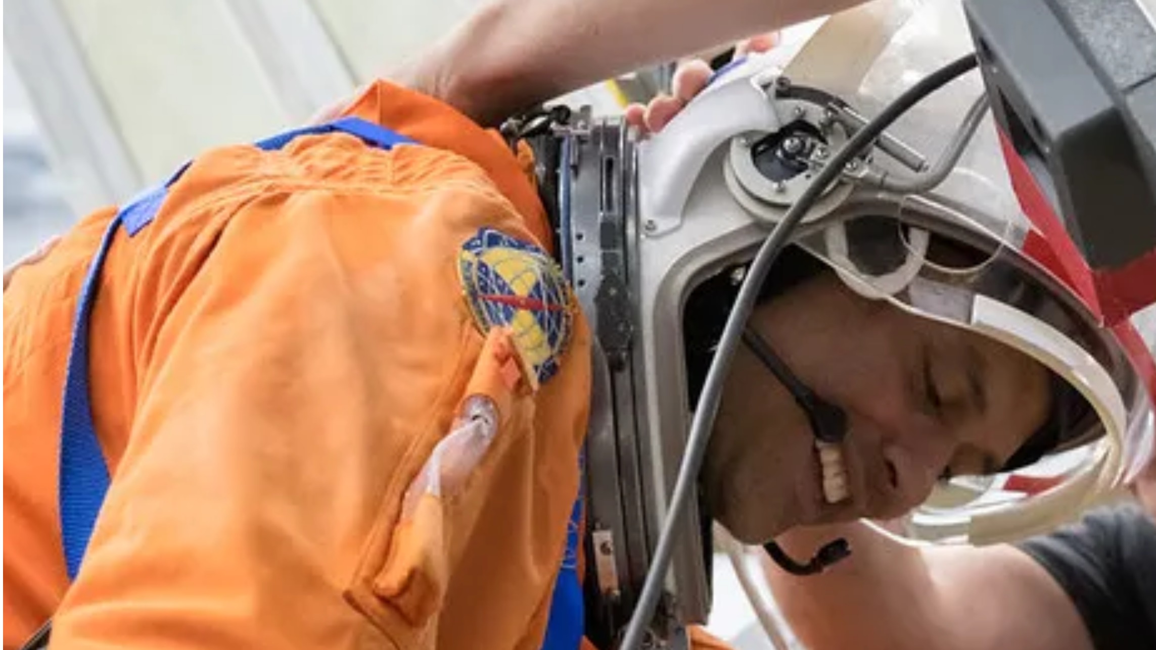 an astronaut leaning over while wearing a spacesuit and helmet