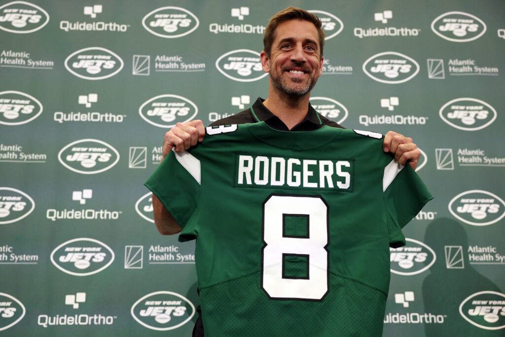 New York Jets quarterback Aaron Rodgers poses with a jersey during an introductory press conference at Atlantic Health Jets Training Center on April 26, 2023 in Florham Park, New Jersey.