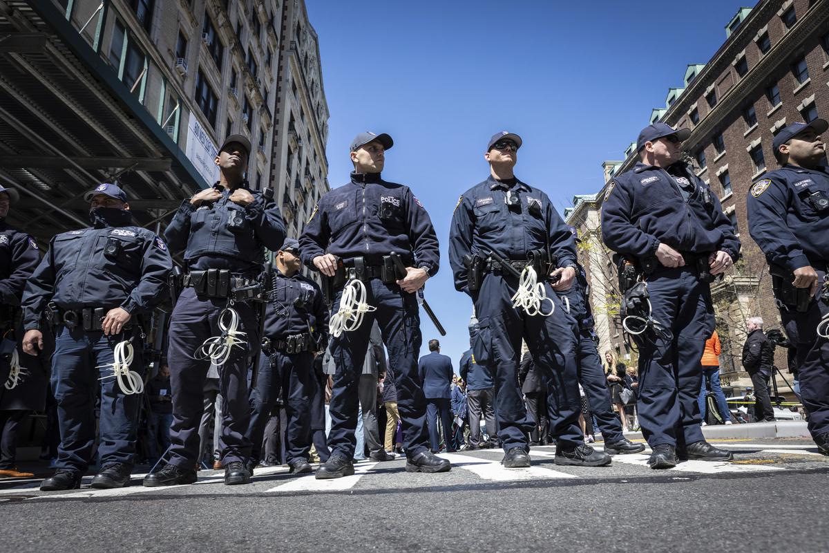 NYPD officers from the Strategic Response Group form a wall of protection around Deputy Commissioner of Legal Matters Michael Gerber and Deputy Commissioner of Operations Kay Daughtry, not in the picture, during a press conference regarding the ongoing pro-Palestinians protest encampment at Columbia University in New York on April 22, 2024.  U.S. colleges and universities are preparing for end-of-year commencement ceremonies with a unique challenge: providing safety for graduates while honoring the free speech rights of students involved in protests over the Israel-Hamas war